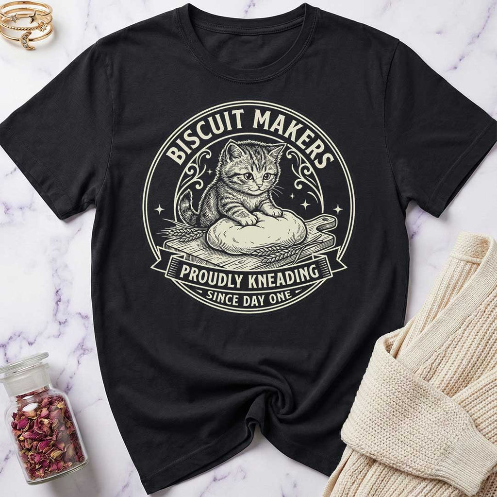 Black t-shirt with a cat graphic and 'Biscuit Makers Union' text on a marble surface.