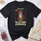Black t-shirt with a graphic design featuring a car and cat, text 'I can go anywhere, the cat decides where', on a marble surface.