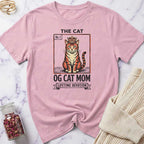 Pink t-shirt with a cat graphic and text on a marble surface
