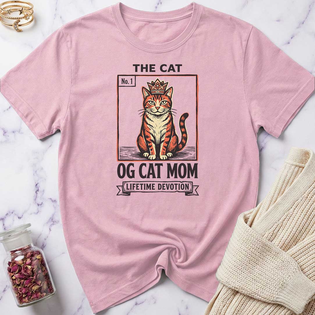 Pink t-shirt with a cat graphic and text on a marble surface