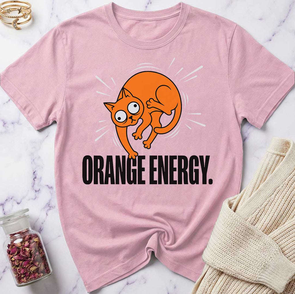 Pink t-shirt with orange cat graphic and 'Orange Energy' text on a marble surface.