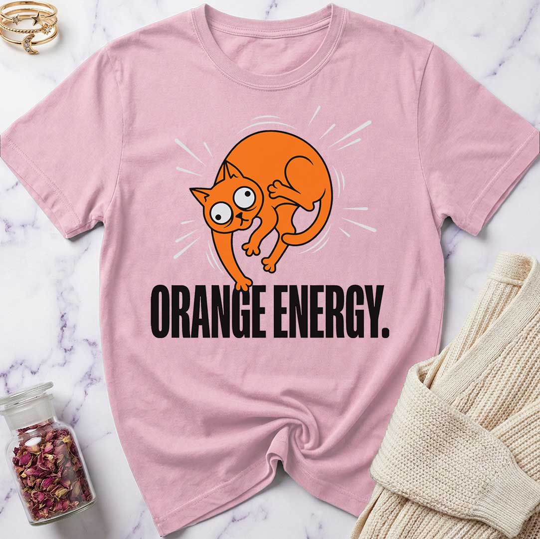 Pink t-shirt with orange cat graphic and 'Orange Energy' text on a marble surface.