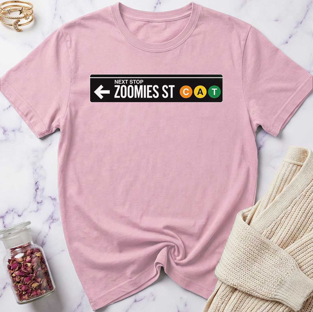 Pink t-shirt with a humorous street sign design on a marble surface.