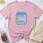 Pink t-shirt with a graphic of a smartwatch and text on a marble surface.