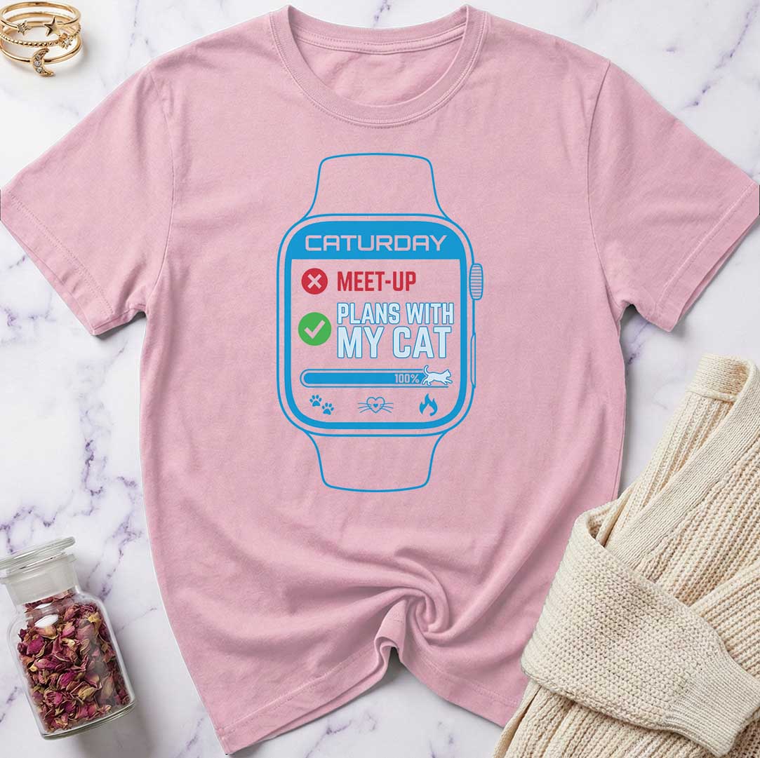 Pink t-shirt with a graphic of a smartwatch and text on a marble surface.