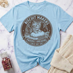 Light blue t-shirt with a cat graphic and text on a marble surface.