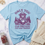 Light blue t-shirt with a graphic of a cat in a hat and text on a marble surface.