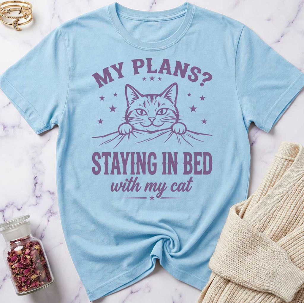 Light blue t-shirt with a cat graphic and text on a marble surface.
