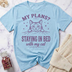 Light blue t-shirt with a cat graphic and text on a marble surface.