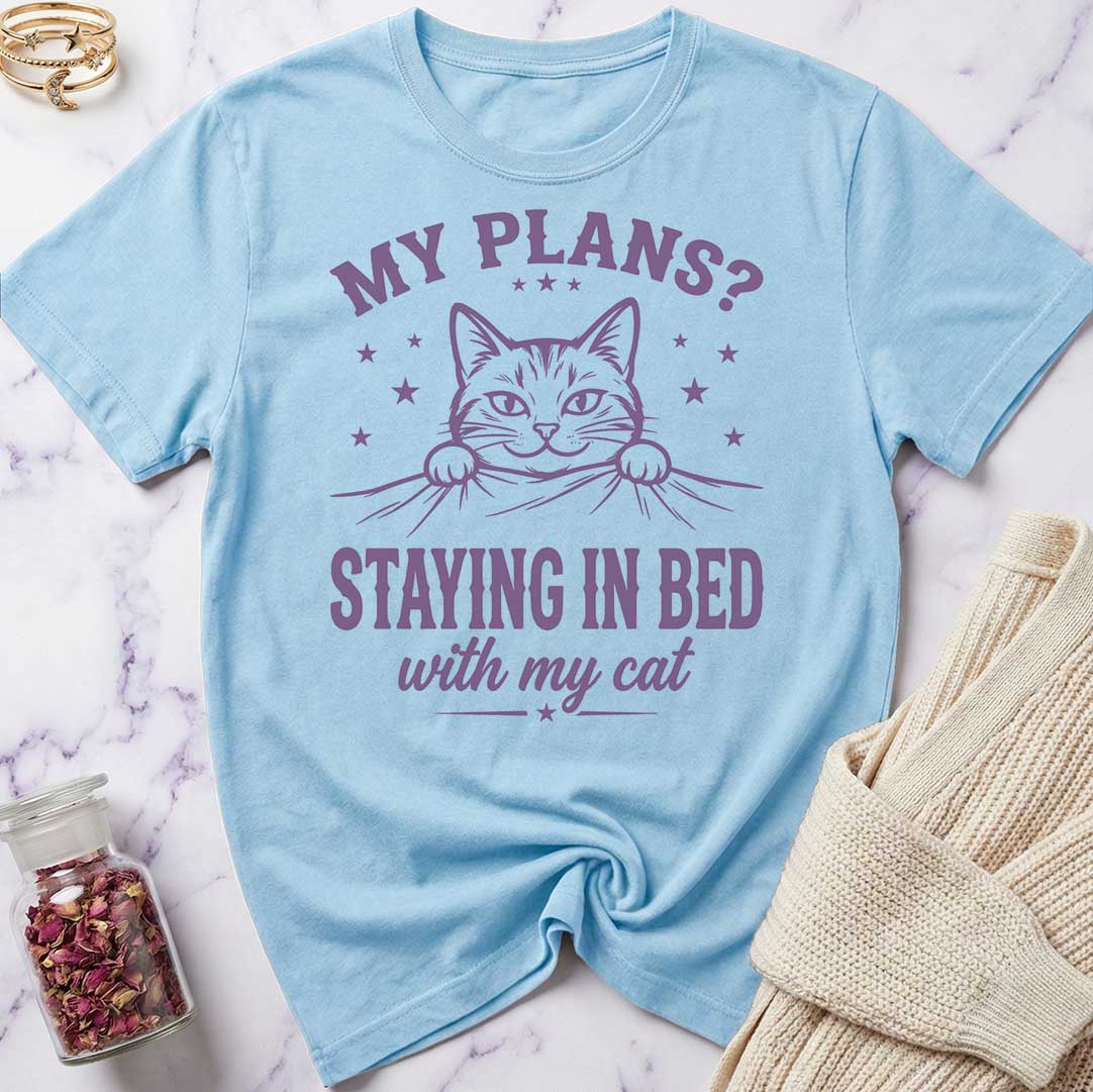 Light blue t-shirt with a cat graphic and text on a marble surface.