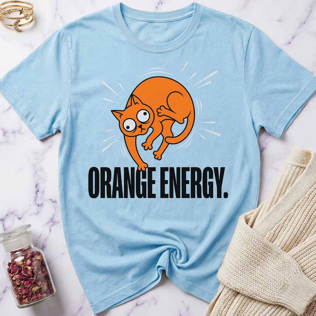 Light blue t-shirt with an orange cat graphic and 'Orange Energy' text on a marble surface.