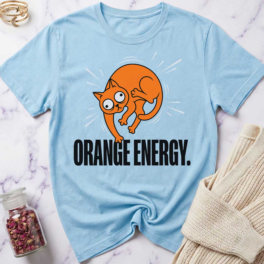 Light blue t-shirt with an orange cat graphic and 'Orange Energy' text on a marble surface.