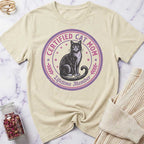 Beige t-shirt with a cat graphic and text on a marble surface