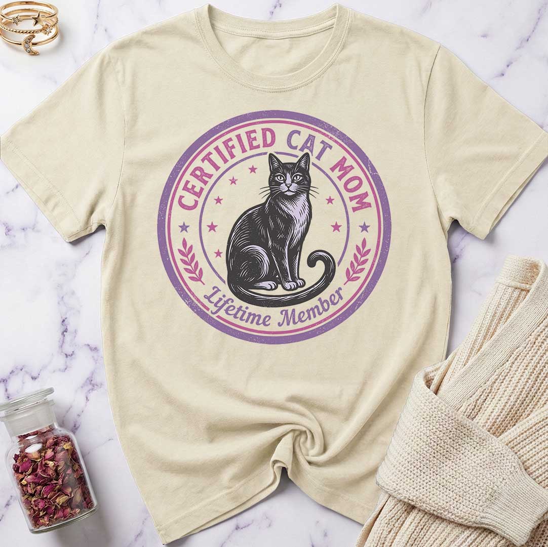 Beige t-shirt with a cat graphic and text on a marble surface