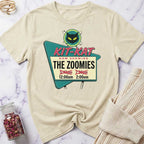Beige t-shirt with a movie theater-themed graphic on a marble surface.