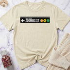 Beige t-shirt with a 'Next Stop Zoomies St CAT' graphic on a marble surface.