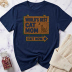 Navy blue t-shirt with 'World's Best Cat Mom Exit Now' text on a marble surface.