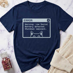 Navy blue t-shirt with a humorous error message design on a marble surface.
