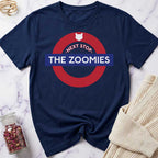 Navy blue t-shirt with 'Next Stop The Zoomies' graphic on a marble surface.