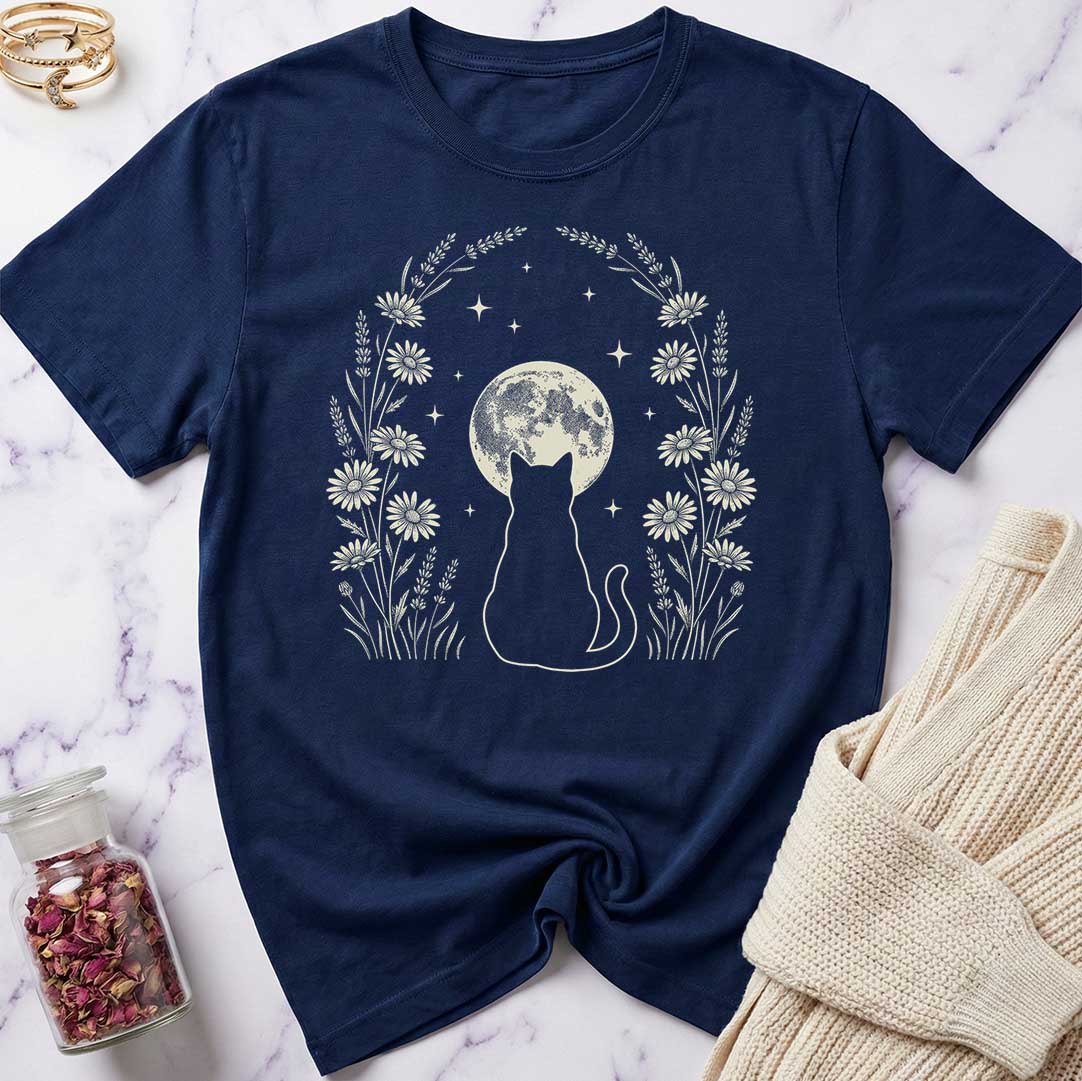 Navy blue t-shirt with a cat and moon design on a marble surface.