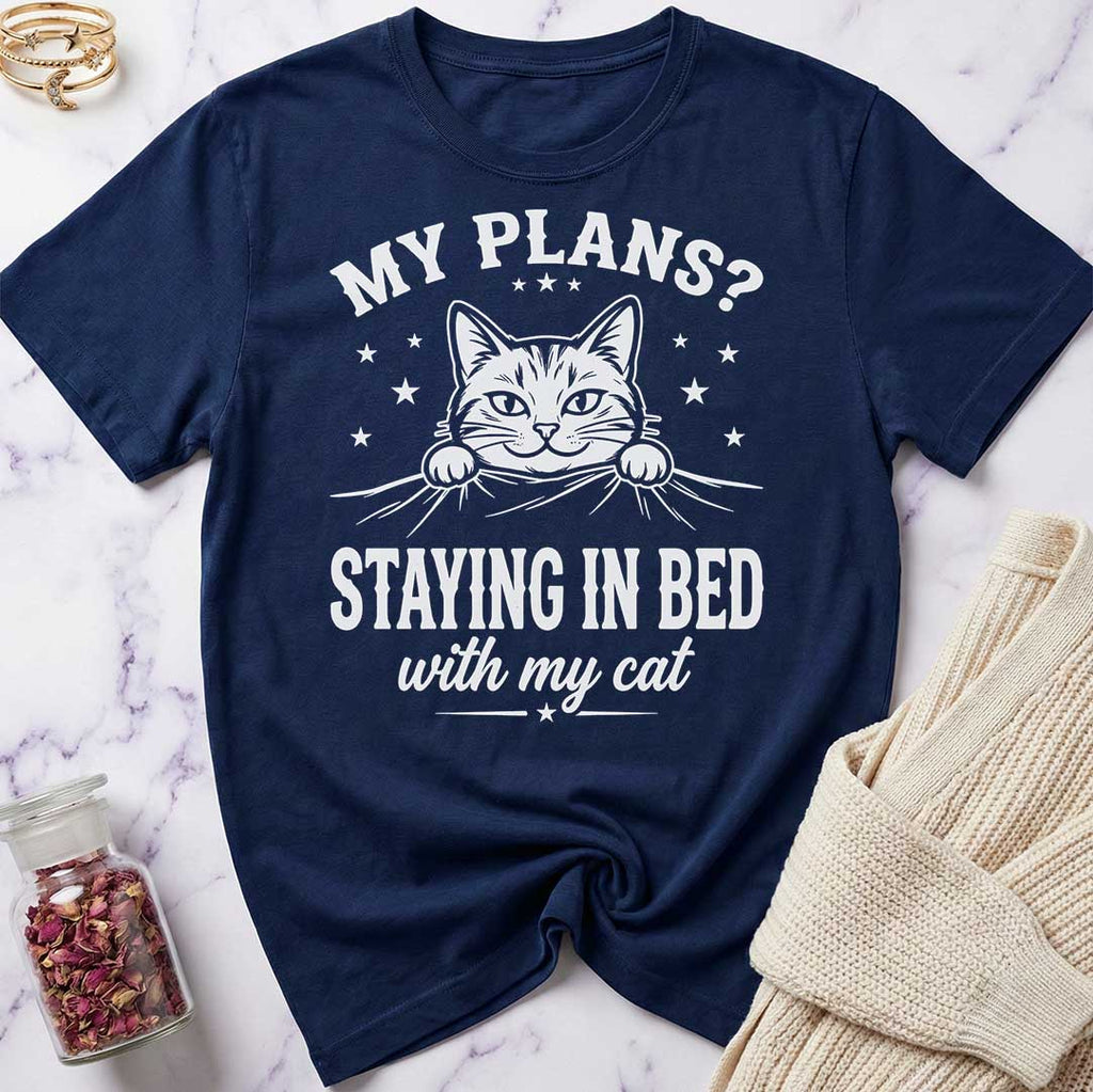Navy blue t-shirt with a cat graphic and text on a marble surface.