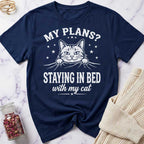 Navy blue t-shirt with a cat graphic and text on a marble surface.