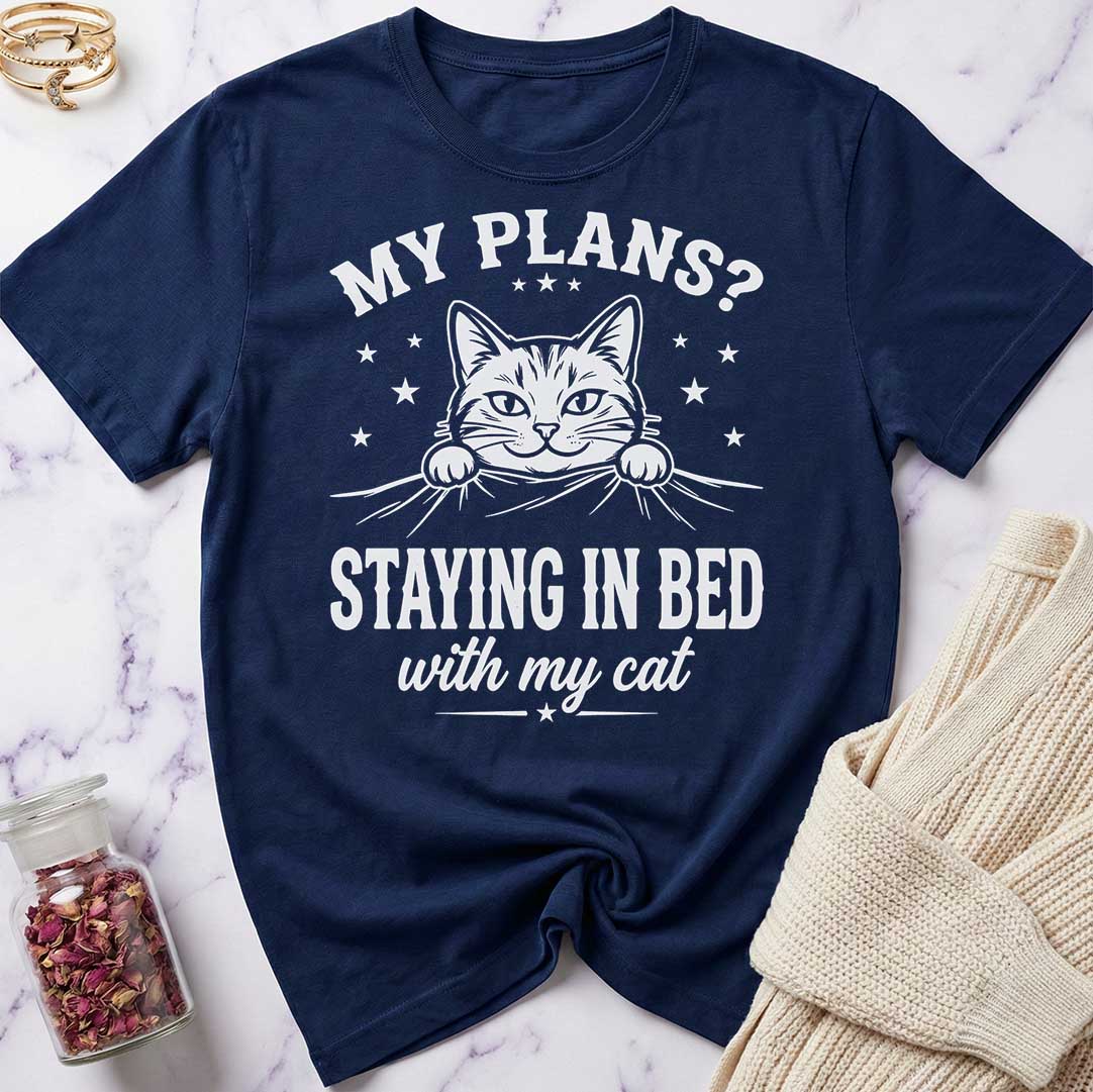 Navy blue t-shirt with a cat graphic and text on a marble surface.