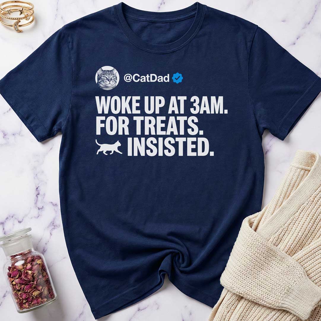 Navy blue t-shirt with humorous text design on a marble surface.