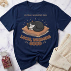 Navy blue t-shirt with a cat graphic and text on a marble surface.