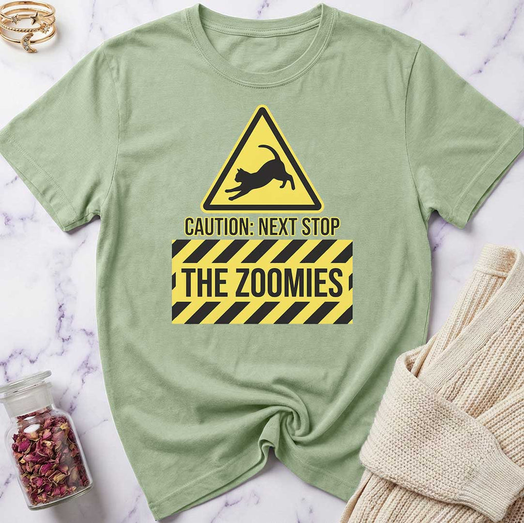 Green t-shirt with a yellow warning sign graphic and text on a marble surface.