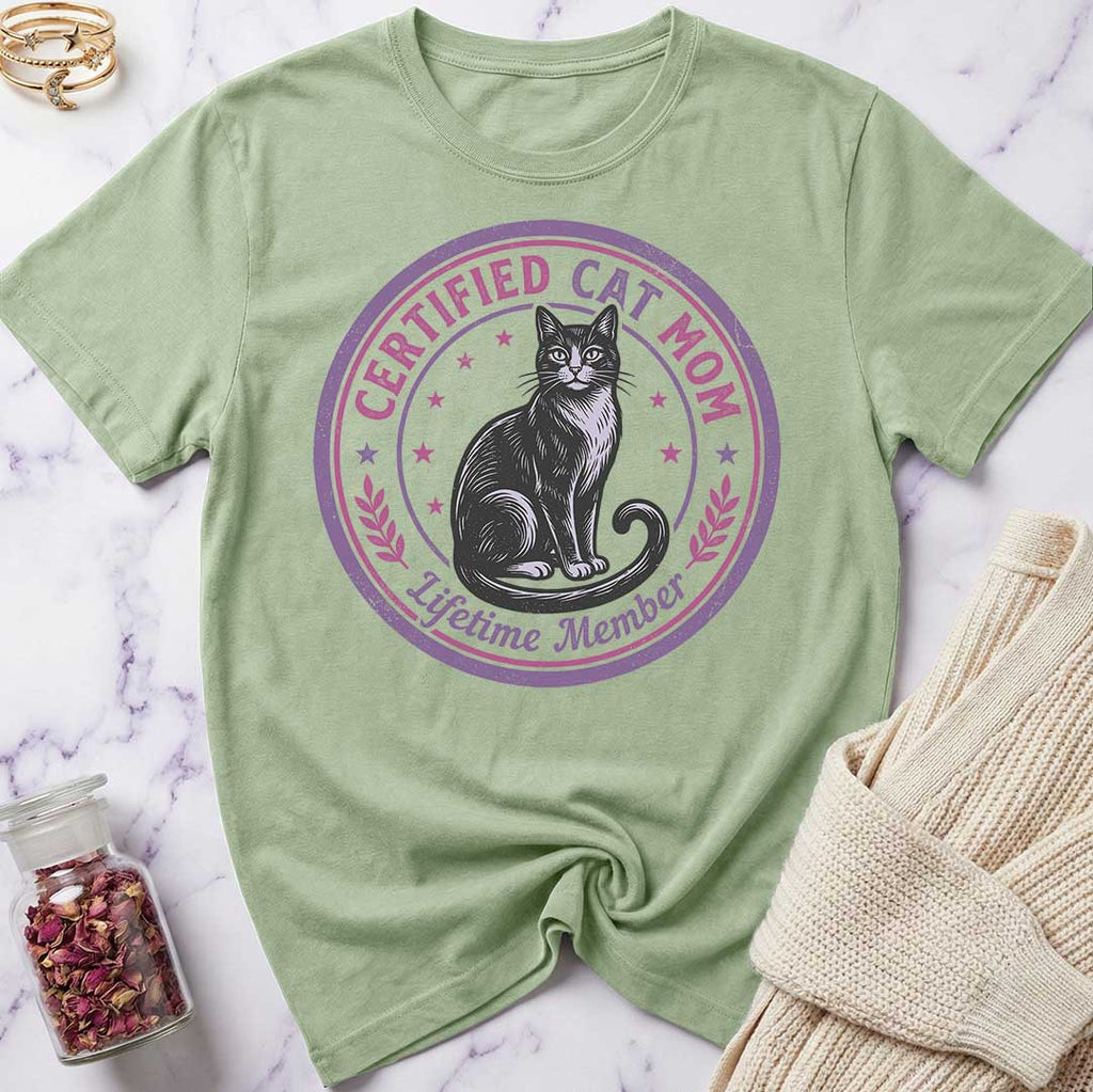 Green t-shirt with a cat graphic and text on a marble surface