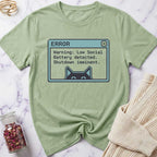 Green t-shirt with a pixelated error message design on a marble surface.