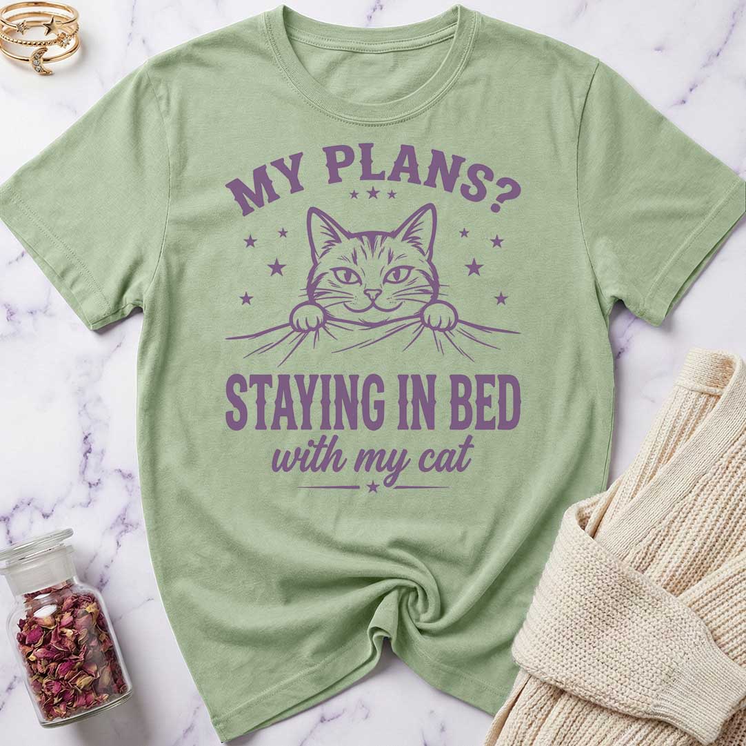 Green t-shirt with a cat graphic and text on a marble surface