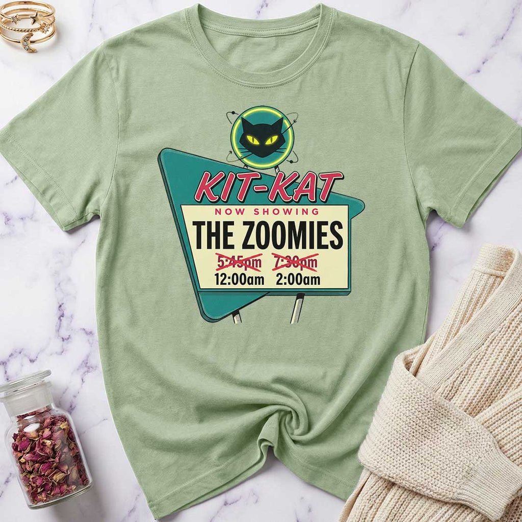 Green t-shirt with a movie poster design featuring 'Kit-Kat' and 'The Zoomies' on a marble surface.