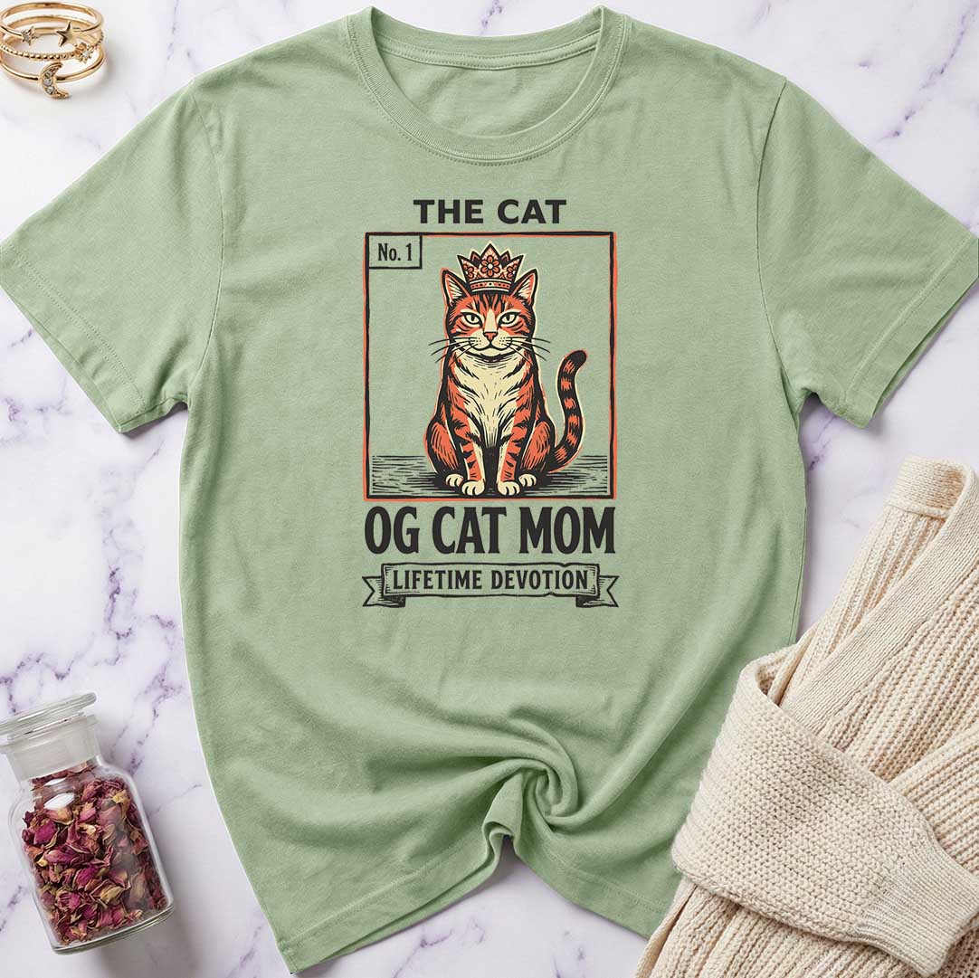 Green t-shirt with a cat graphic and text on a marble surface