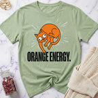 Green t-shirt with orange cat graphic and 'Orange Energy' text on a marble surface.
