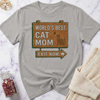 Gray t-shirt with 'World's Best Cat Mom Exit Now' graphic on a marble surface.