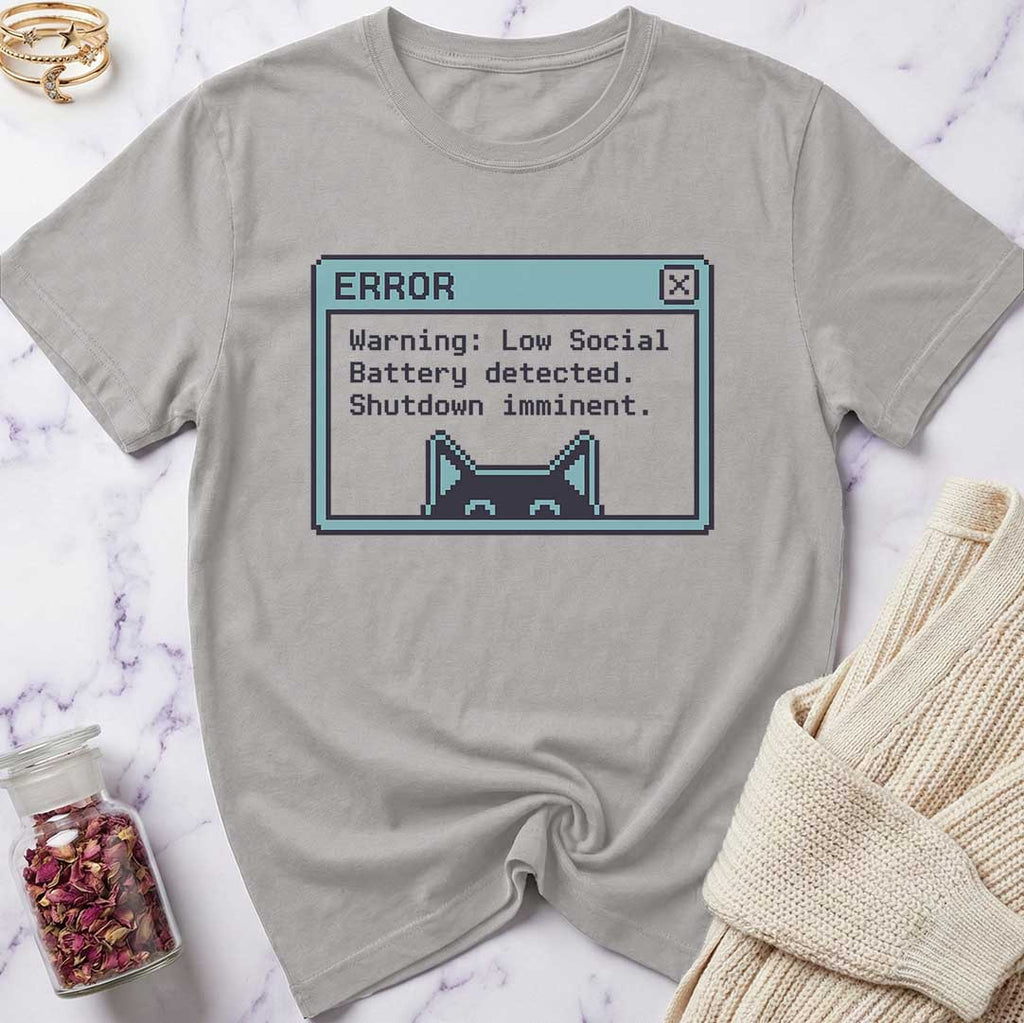 Gray t-shirt with a pixelated error message design on a marble surface.