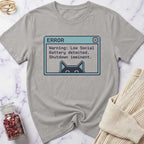 Gray t-shirt with a pixelated error message design on a marble surface.