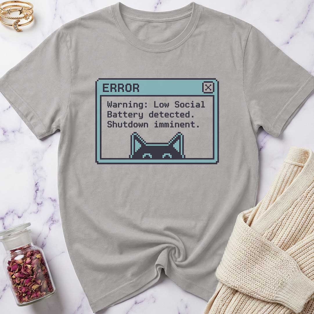 Gray t-shirt with a pixelated error message design on a marble surface.