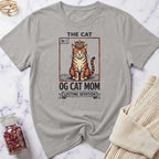 Gray t-shirt with a cat graphic and text on a marble surface