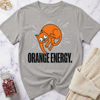 Gray t-shirt with an orange cat graphic and 'Orange Energy' text on a marble surface.