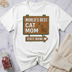 White t-shirt with 'World's Best Cat Mom Exit Now' design on a marble surface.