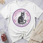 White t-shirt with a cat graphic and text on a marble surface