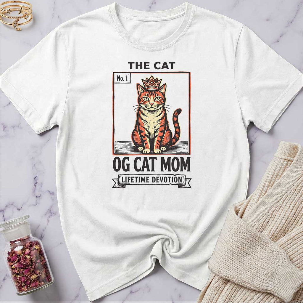 White t-shirt with a cat graphic and text on a marble surface