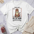 White t-shirt with a cat graphic and text on a marble surface
